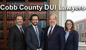Group of DUI lawyers standing in an office with law books and courthouse visible through window